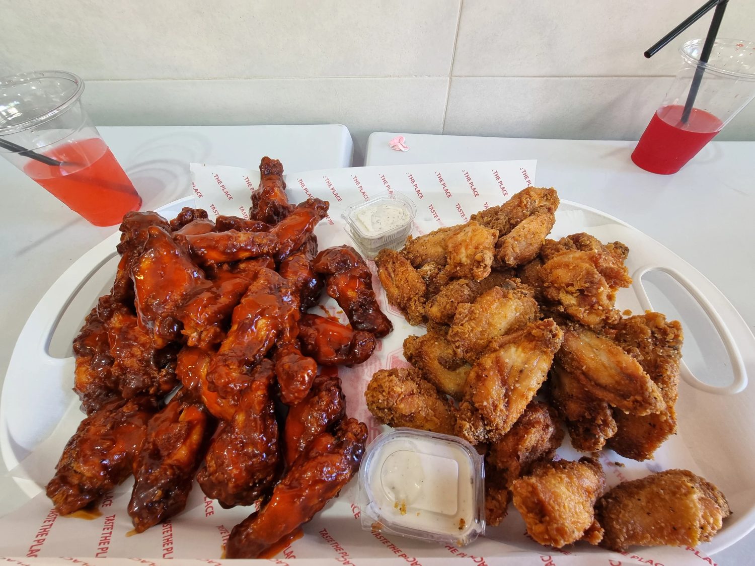 A full platter of BBQ and fried wings with dips